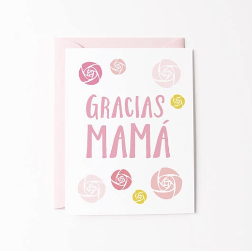 White card with various shades of pink roses surrounding the words Gracias Mama written in pink. Great card for Mother's day or to thank Mom just because